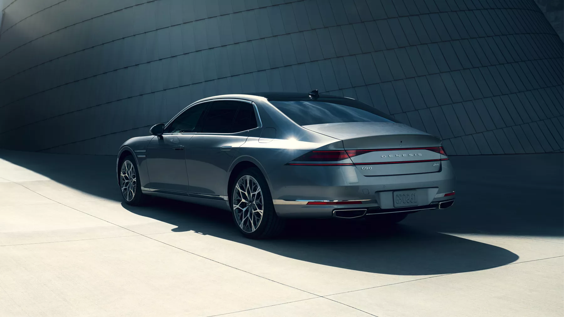 Rear trunk and tail lights of G90 parked in front of building.