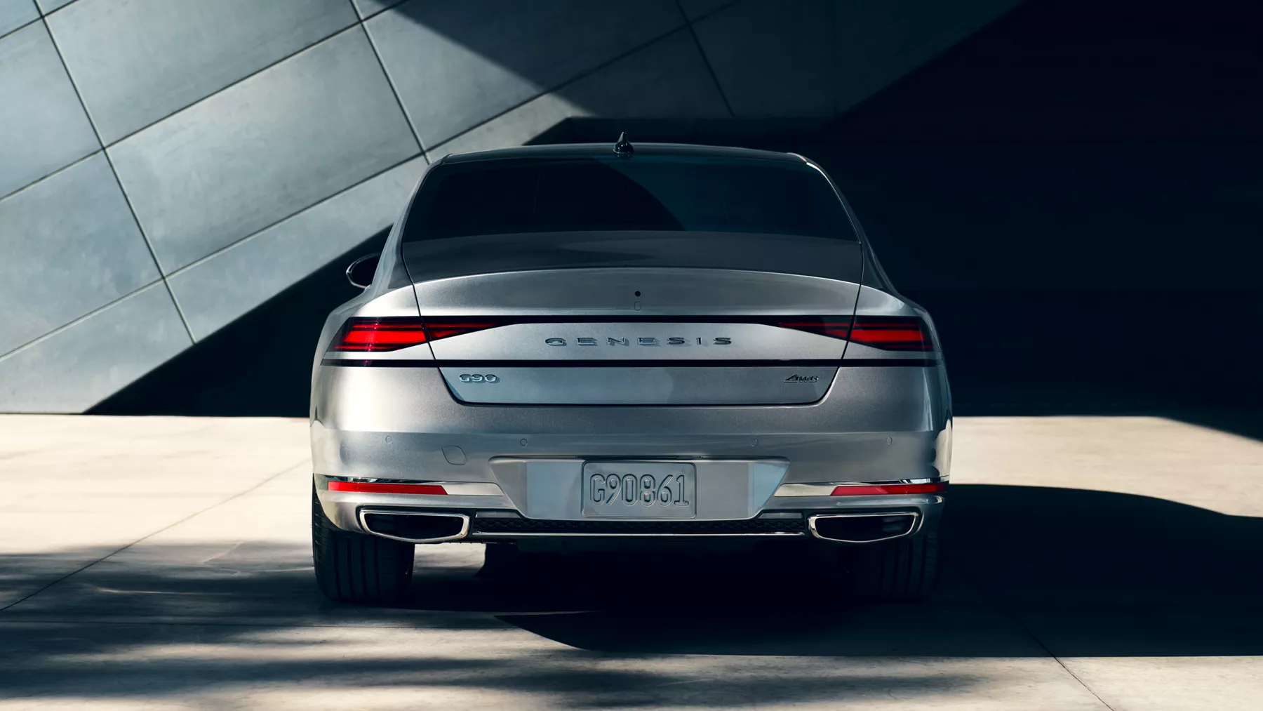 Trunk and rear tail lights of G90 parked in front of a building.