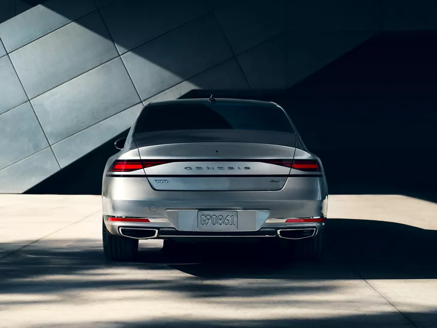 Trunk and rear tail lights of G90 parked in front of a building.