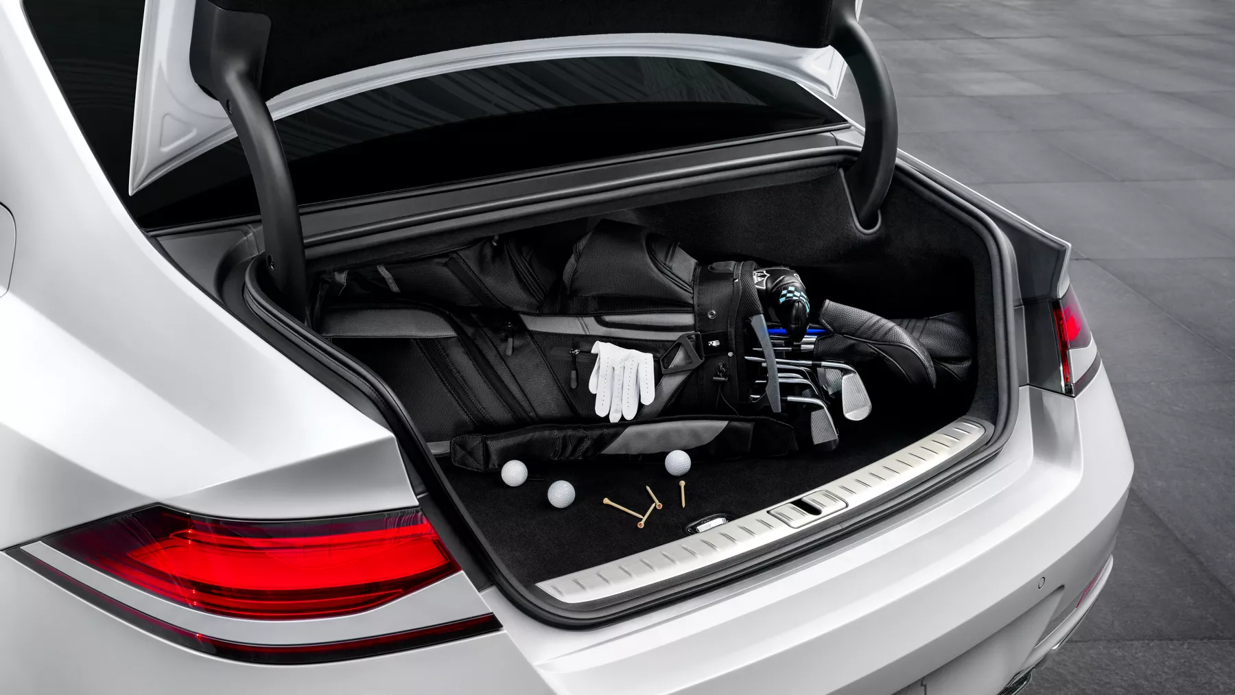 G90 opened trunk with golf bag and clubs inside.