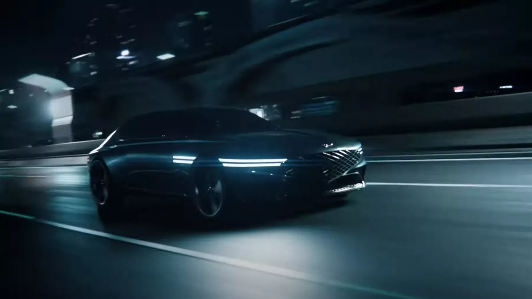 X Concept vehicle driving on highway at night with headlights illuminated.