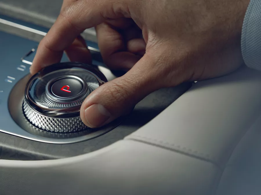 Human hand adjusting dial on Electrified G80 center console.