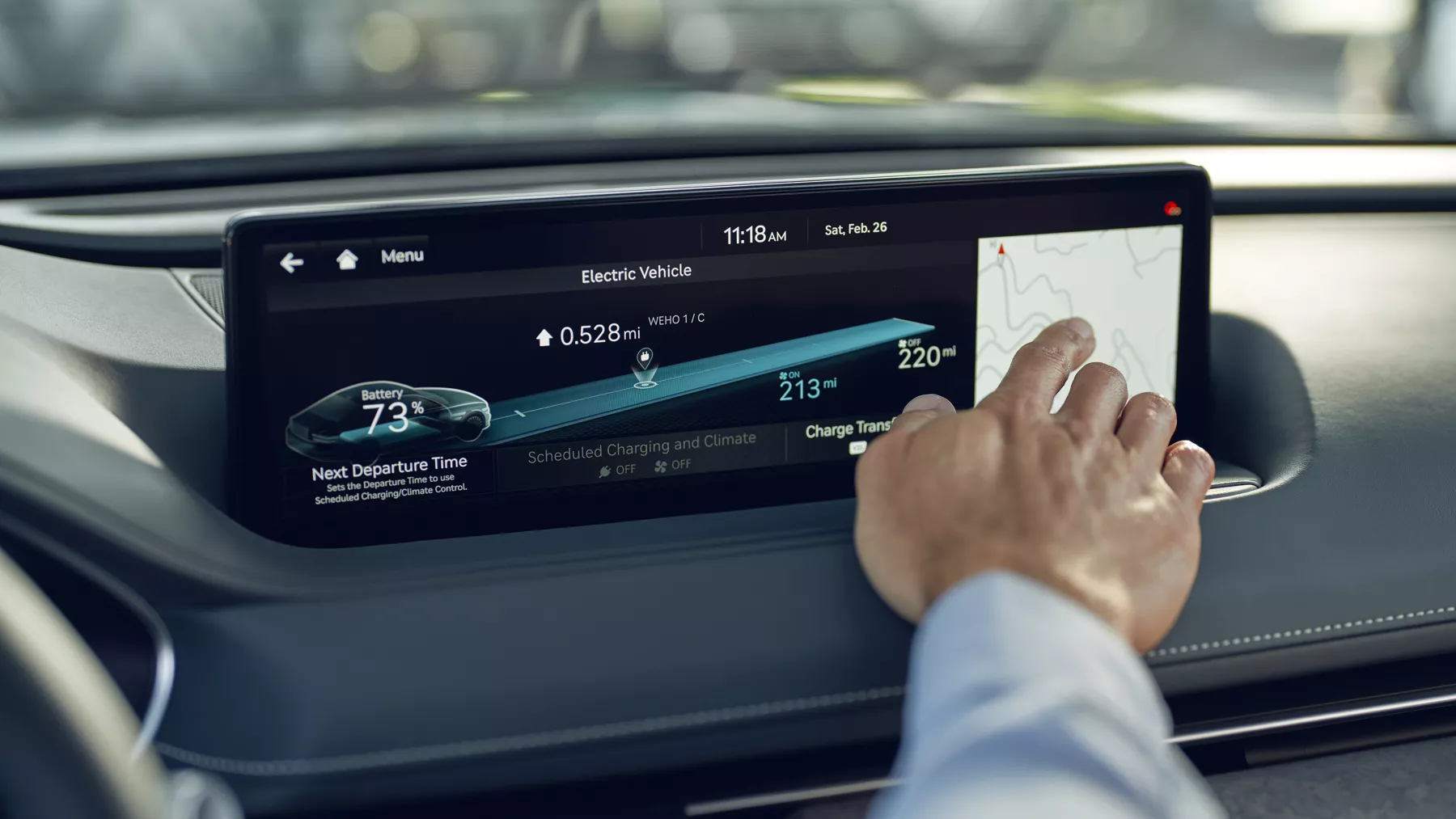 Human hand touching Electrified G80 infotainment screen.