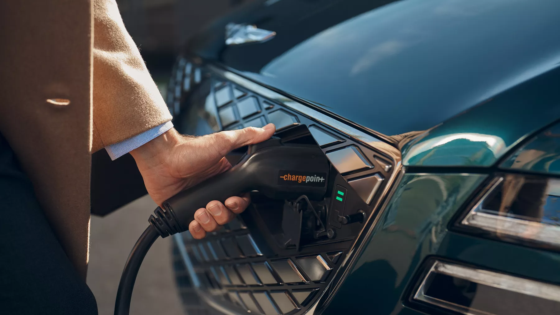 La mano de una persona colocando un cargador en el Electrified G80.