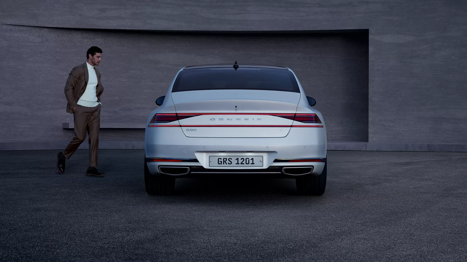 Person walking to driver's-side door of parked G90.