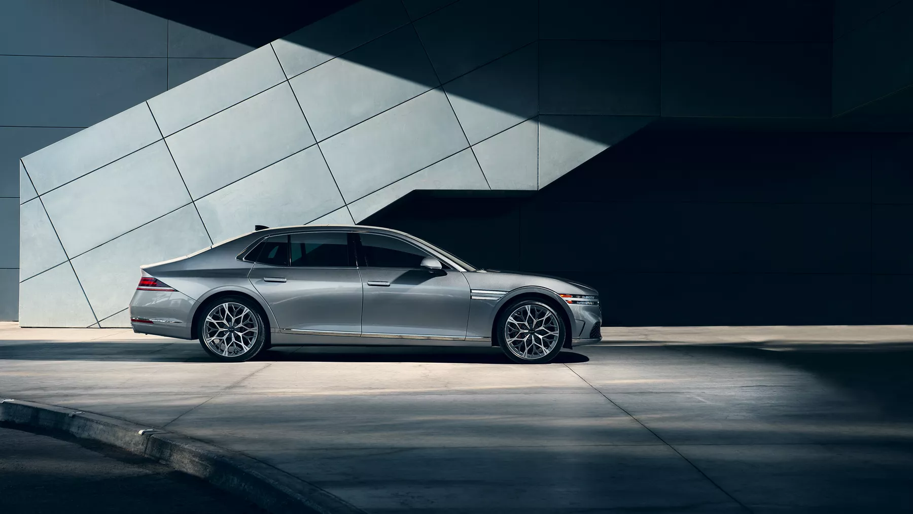 Side profile of G90 parked in front of building.