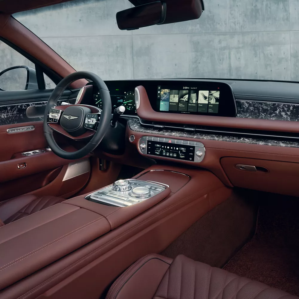 G90 front cabin showing steering wheel and infotainment screen.