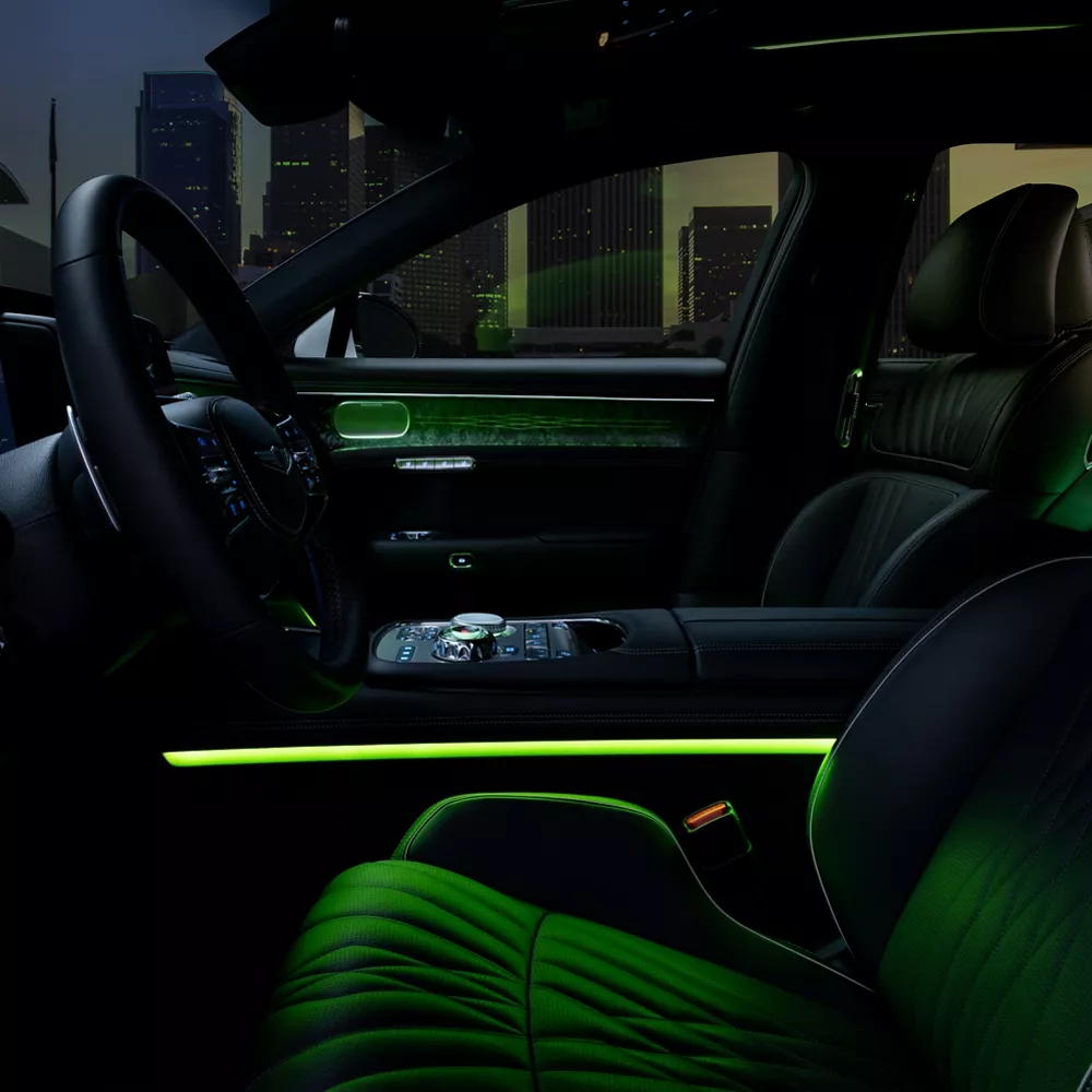 Cabina delantera del G90 de noche con luz ambiental verde.