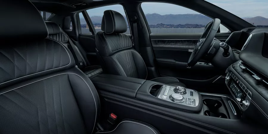 Rear passenger view of 2026 Genesis G90 interior in Black Monotone, with mountains in background