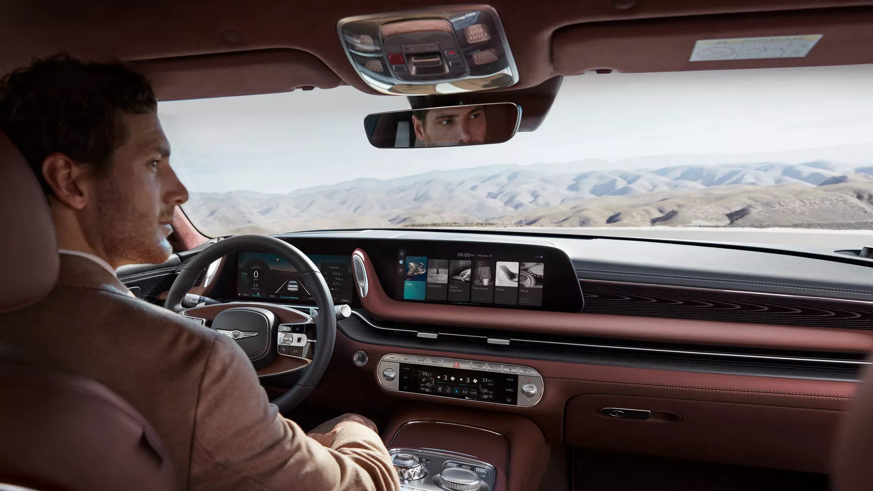 Hombre sentado en el asiento del conductor, conduciendo un G90 en el desierto.