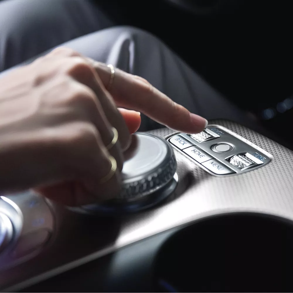 Human hand touching crystal sphere on GV60 center console.