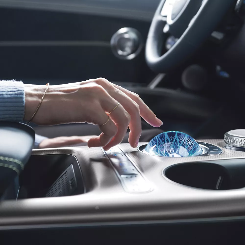 Human hand touching crystal sphere on GV60 center console.