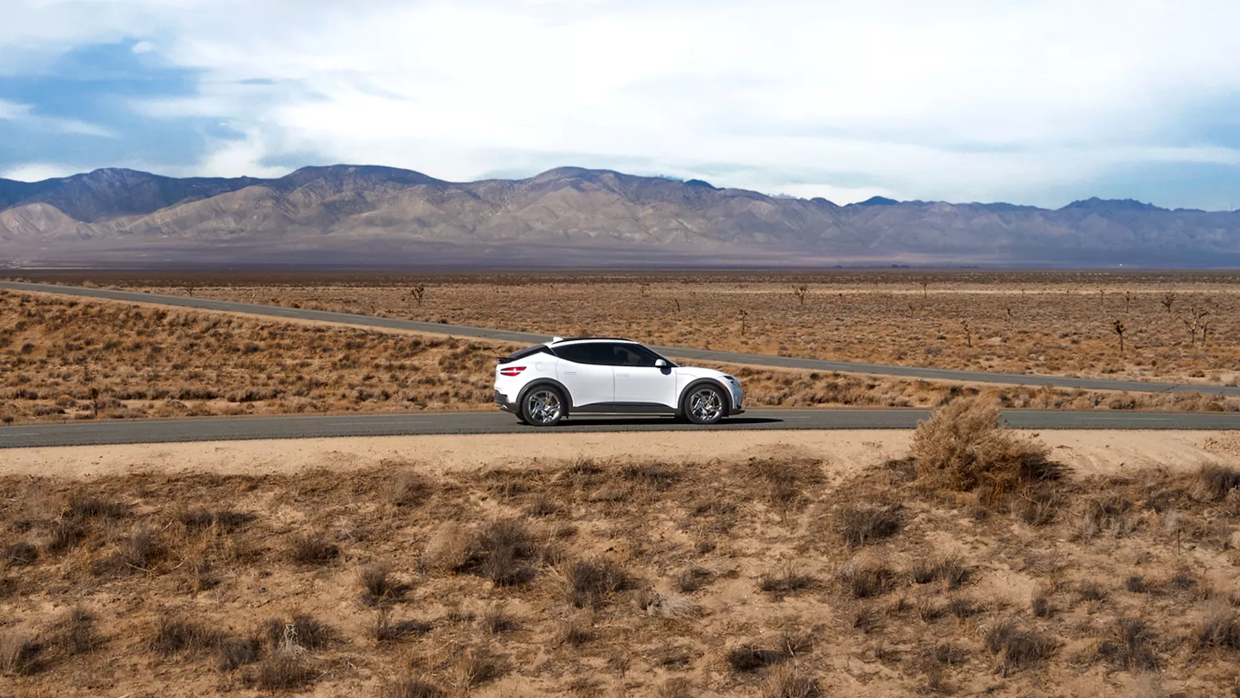 GV60 driving down a desolate desert road. 