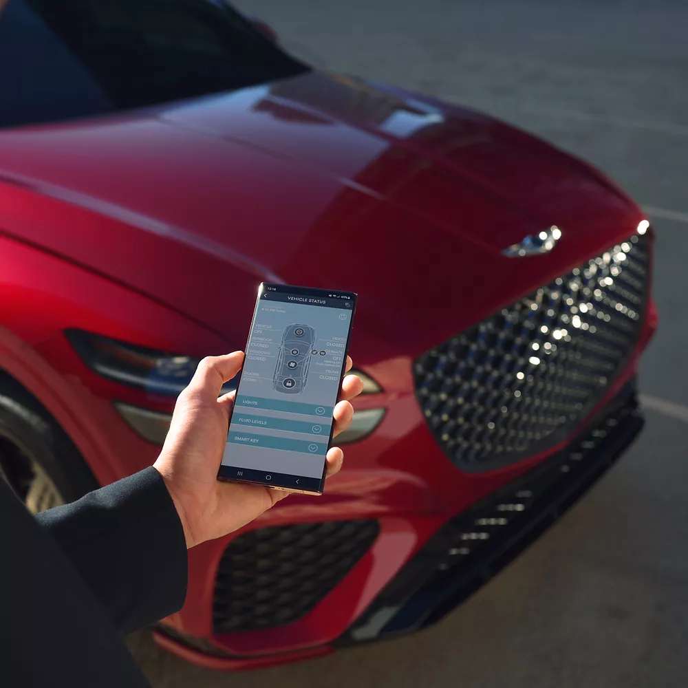 Human hand holding a smartphone displaying an image of GV70. 