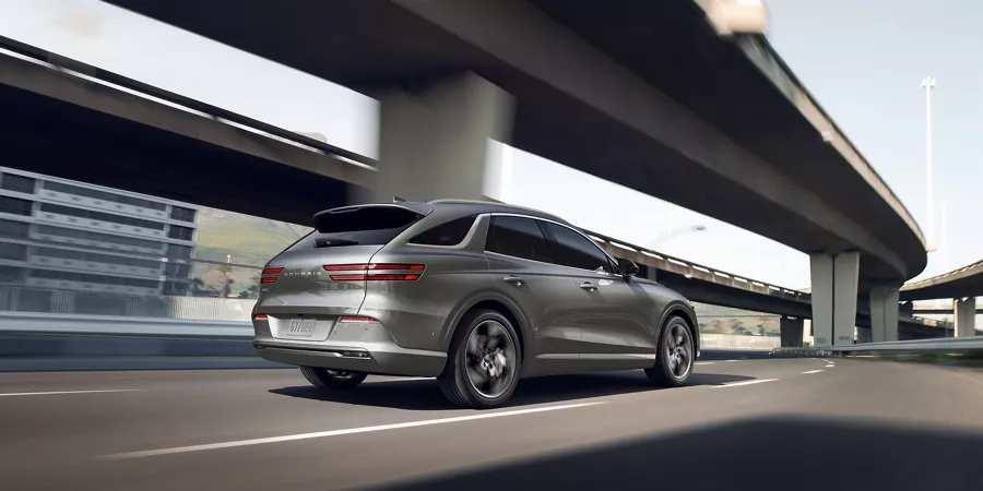 Electrified GV70 driving down a highway.