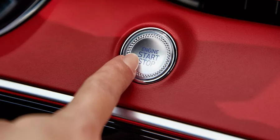 Human finger pushing button on GV70 dashboard.