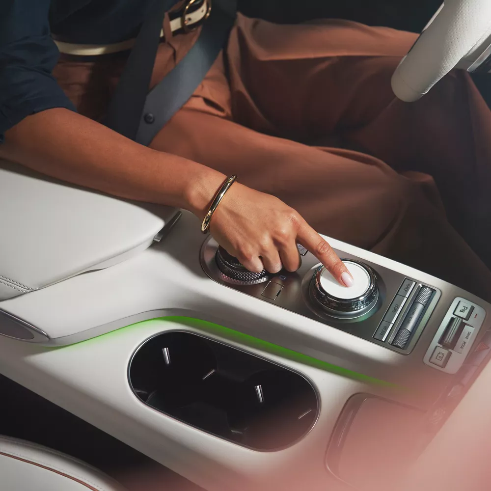 Human hand adjust dial on Electrified GV70 center console.