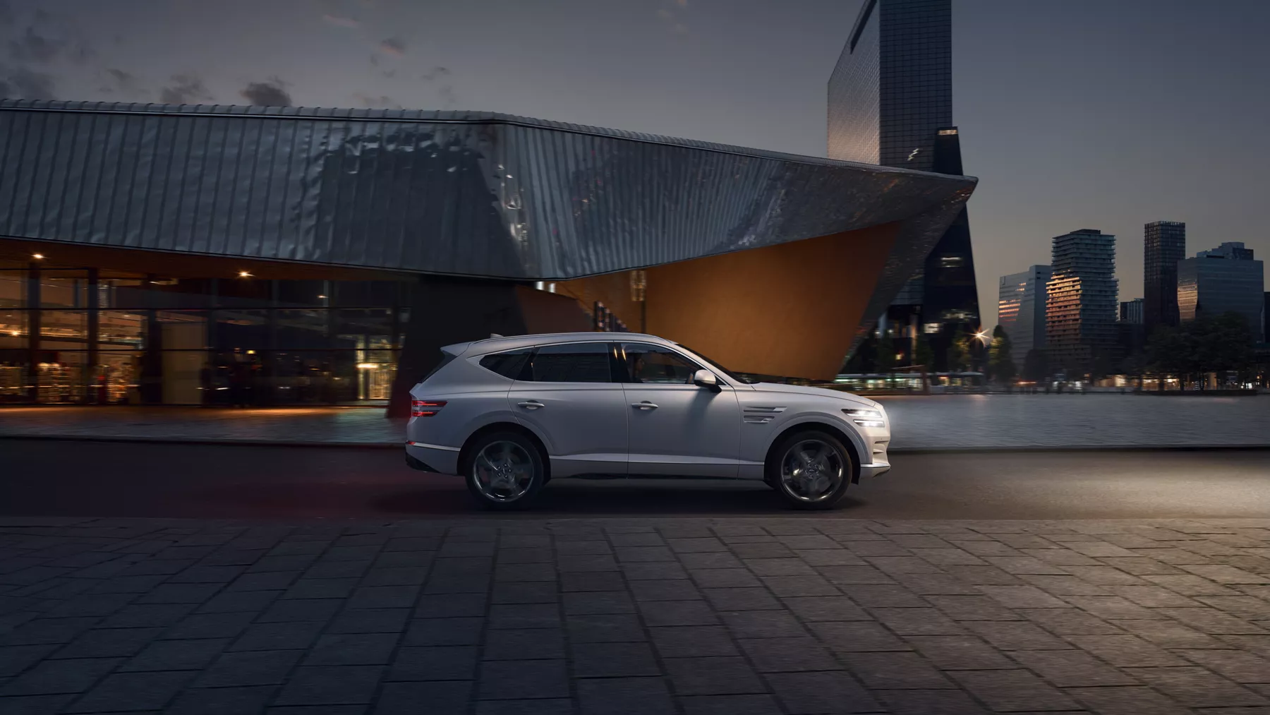 GV80 parked in front of trendy building at night.