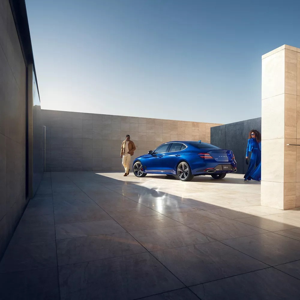 Person standing next to G70 in a concrete structure.