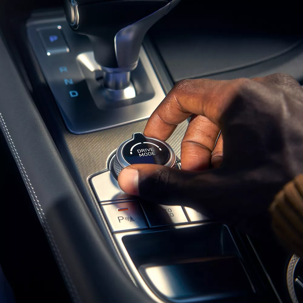 Hand adjusting Drive Mode knob on center console of G70.
