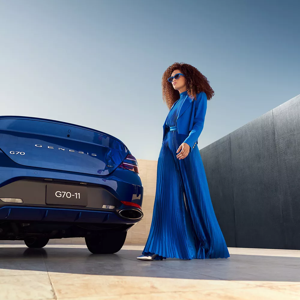 Rear view of G70 with woman in foreground.