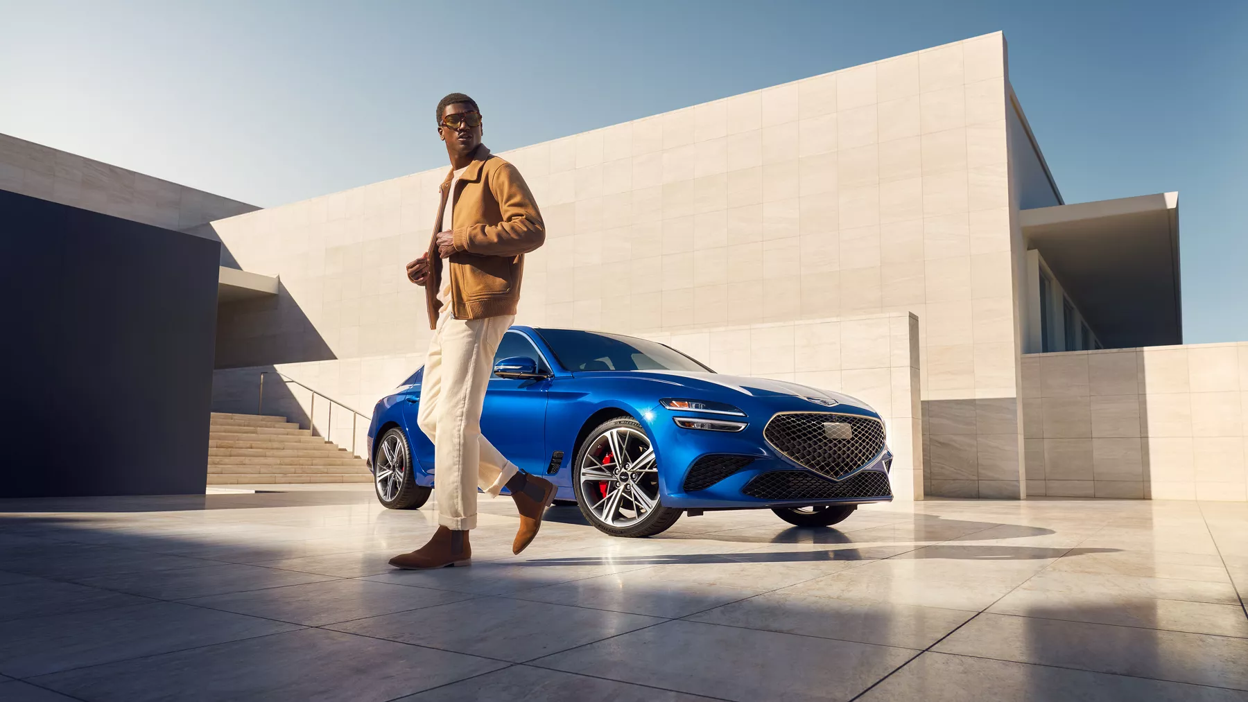 G70 parked near building with man in foreground.