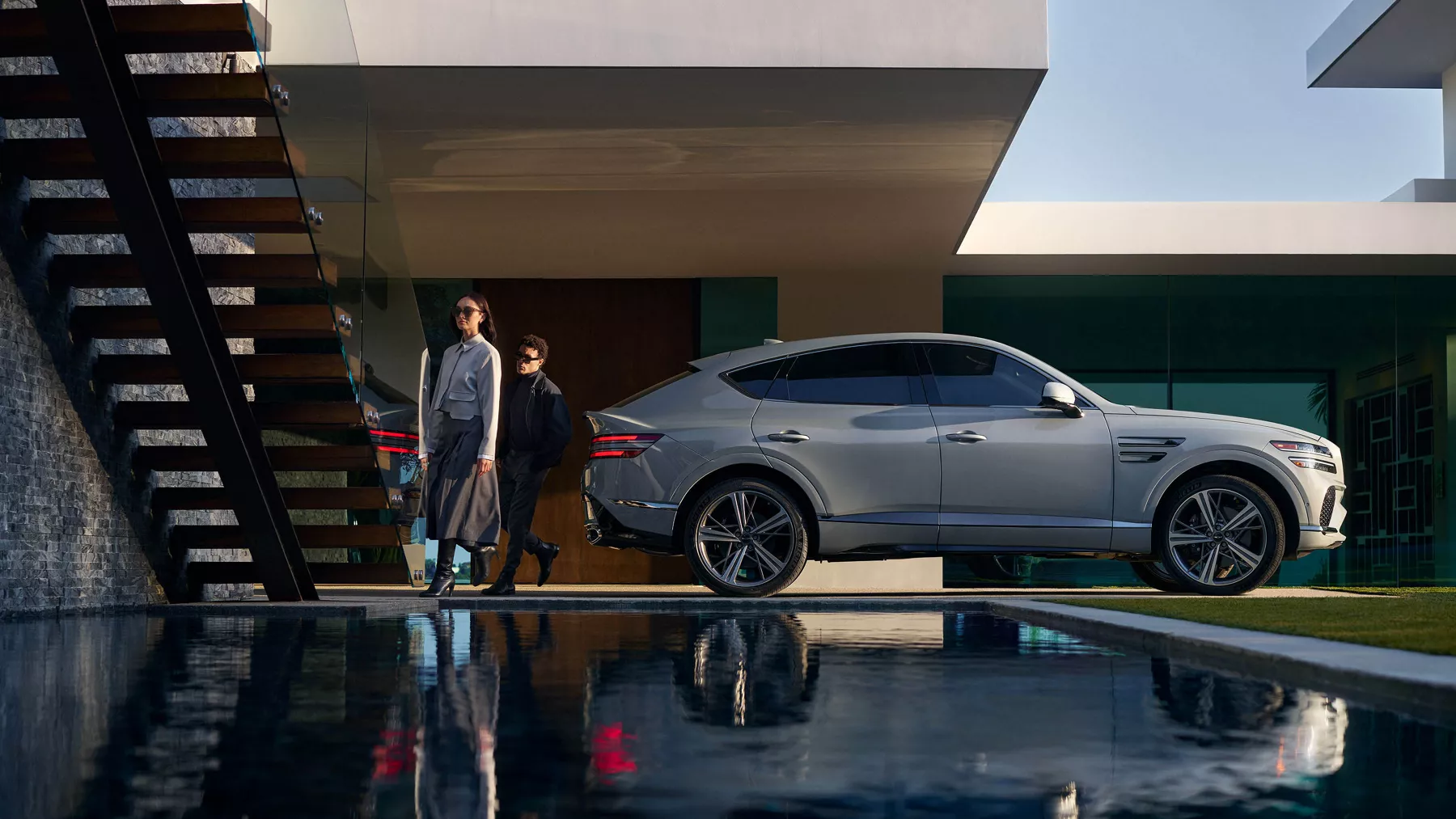 A modern house with the GV80 Coupe parked in between the house and the pool.