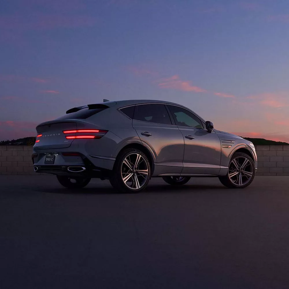 GV80 Coupe driving at dusk in the desert.