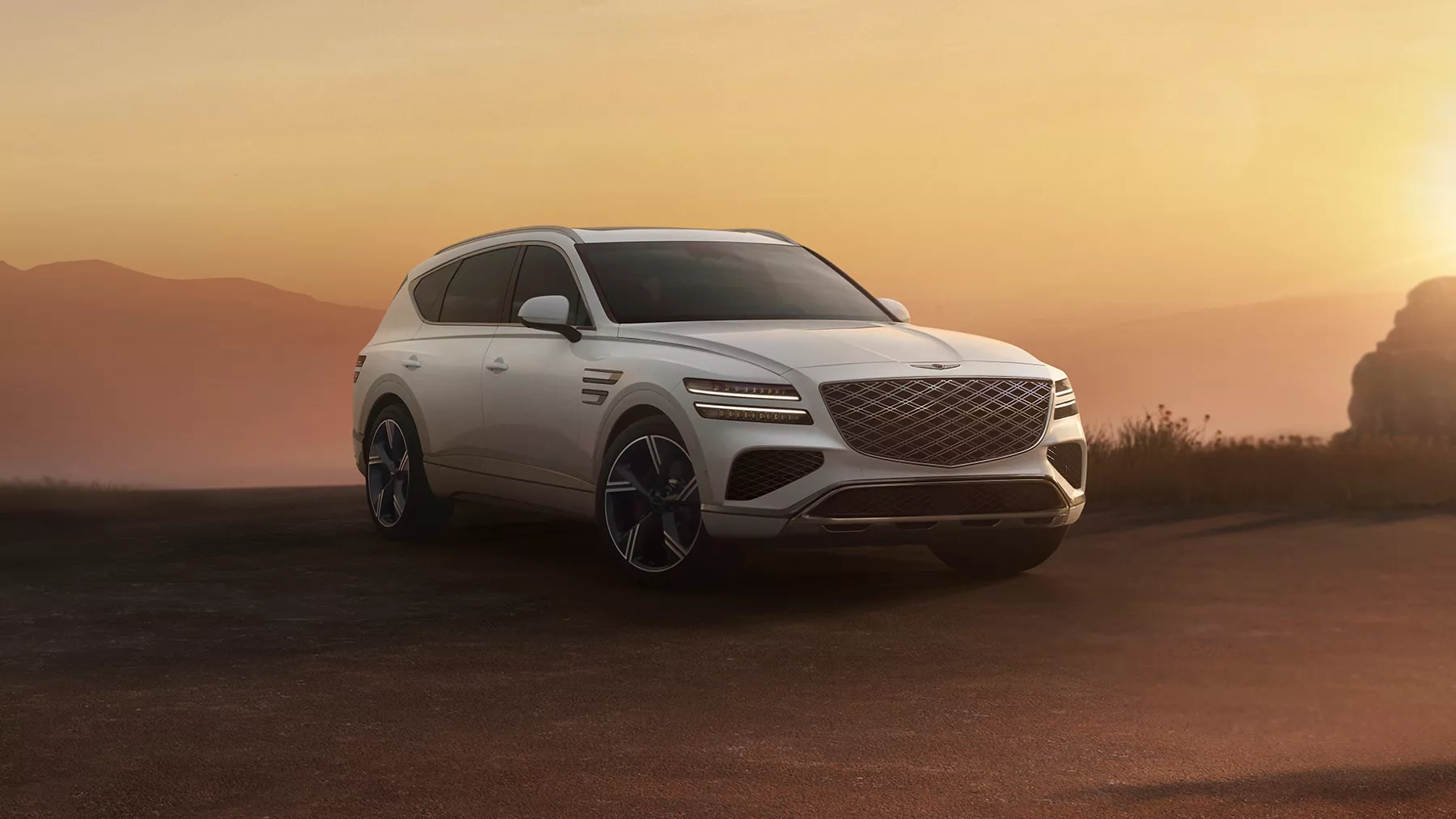 White GV80 parked in a desert setting.