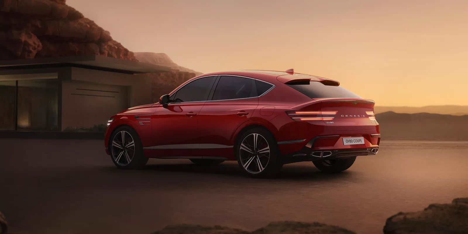 Red Genesis GV80 parked in a driveway at dusk