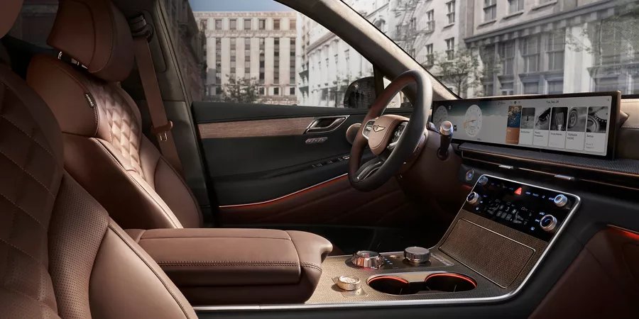 Interior front passenger side pov of Genesis GV80 cabin with brown quilted nappa leather seating
