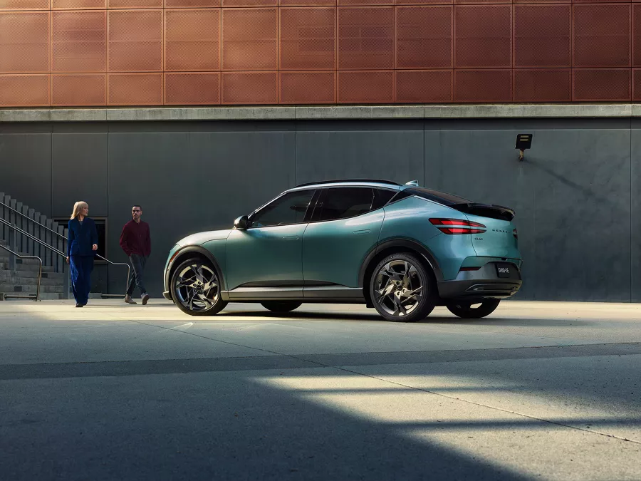 A couple walks toward a parked GV60.