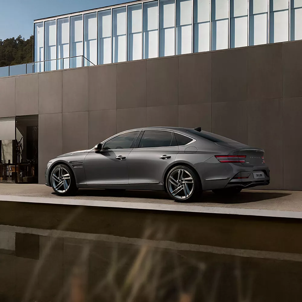 G80 parked in front of fashionable house.