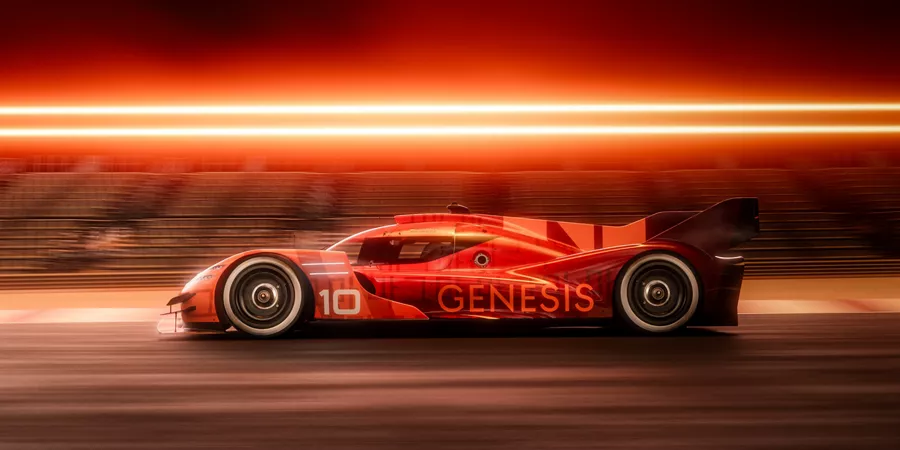 Side profile view of orange Genesis Magma Racing 2025 GMR-001 Hypercar on a race track