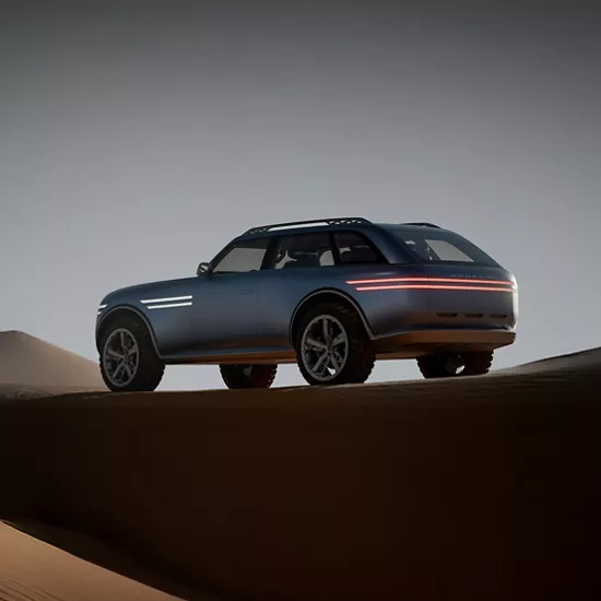 Rear driver side 3/4 view of Genesis X Gran Equator Concept vehicle parked on a sand dune at dusk