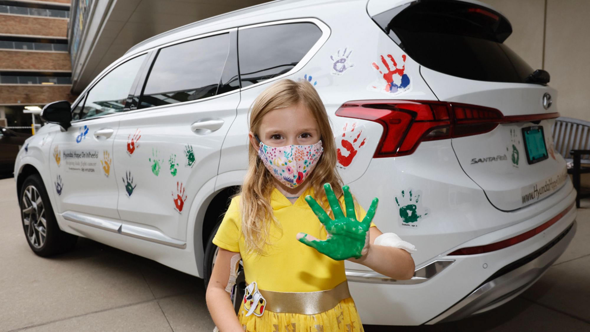 Girls with handprint next to Hyundai vehicle