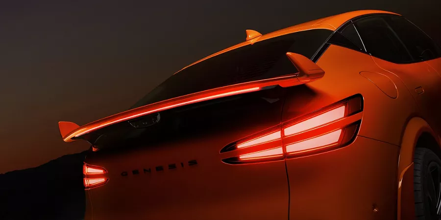 Rear spoiler and brake lights close up on 2027 Genesis GV60 Magma in orange