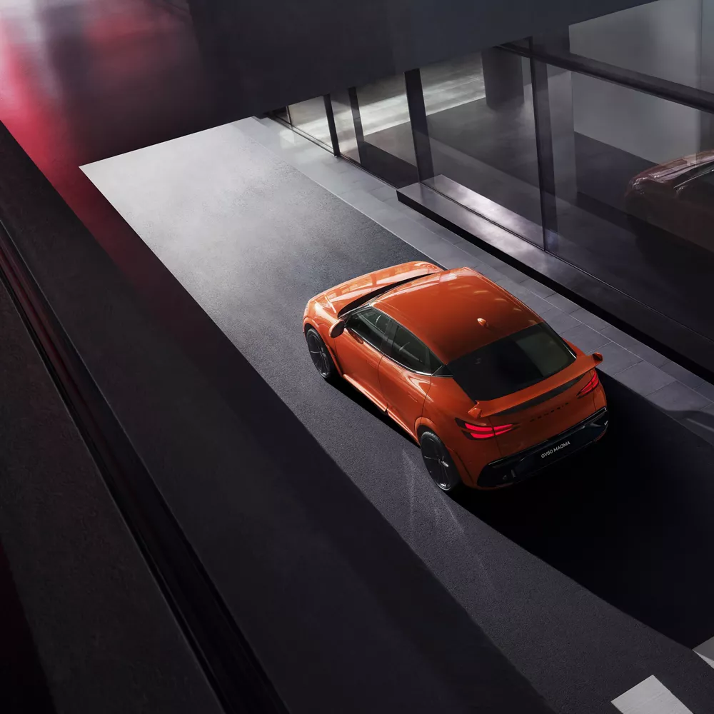 Aerial 3/4 rear driver side view of 2027 Genesis GV60 Magma in orange