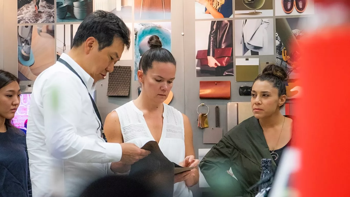 Hyundai engineers and designers look at a car design board hanging on the wall