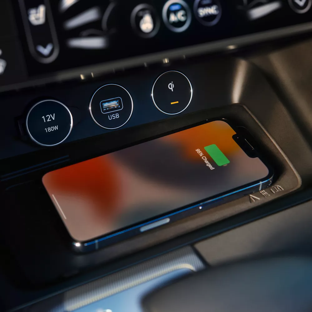 Close up interior shot of phone charging on wireless charger bed in Genesis G70