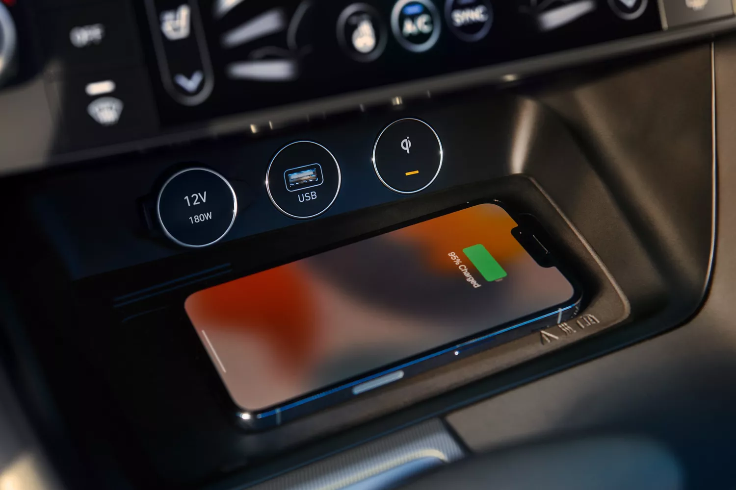 Interior closeup of phone on wireless charging station inside 2027 Genesis G70