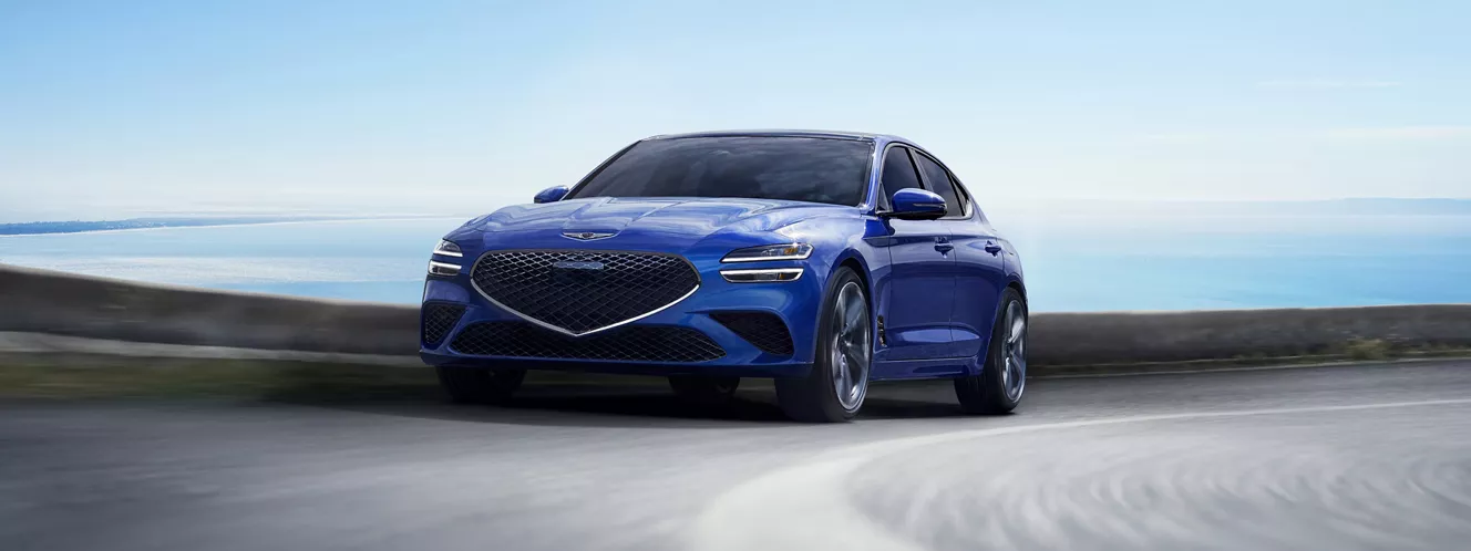 Genesis G70 (Kawah Blue) 行駛於濱海公路上前座駕駛側行進間畫面