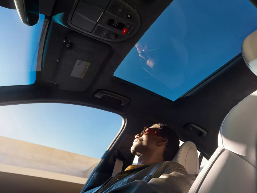 Low angle shot from driver side of man sitting in passenger seat of Genesis G70 3.3T Sport Prestige