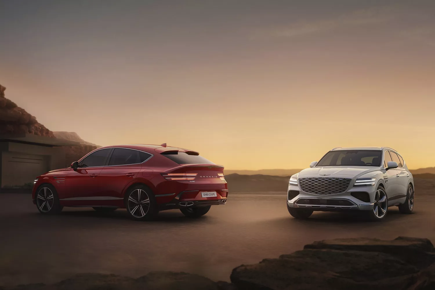 View of two Genesis GV80 Coupes in Mauna Red and Uyuni White parked outside house at dusk