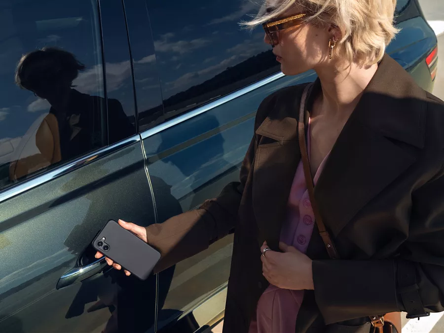 Close up exterior shot of person holding smartphone Digital Key up to Genesis GV80 driver side door