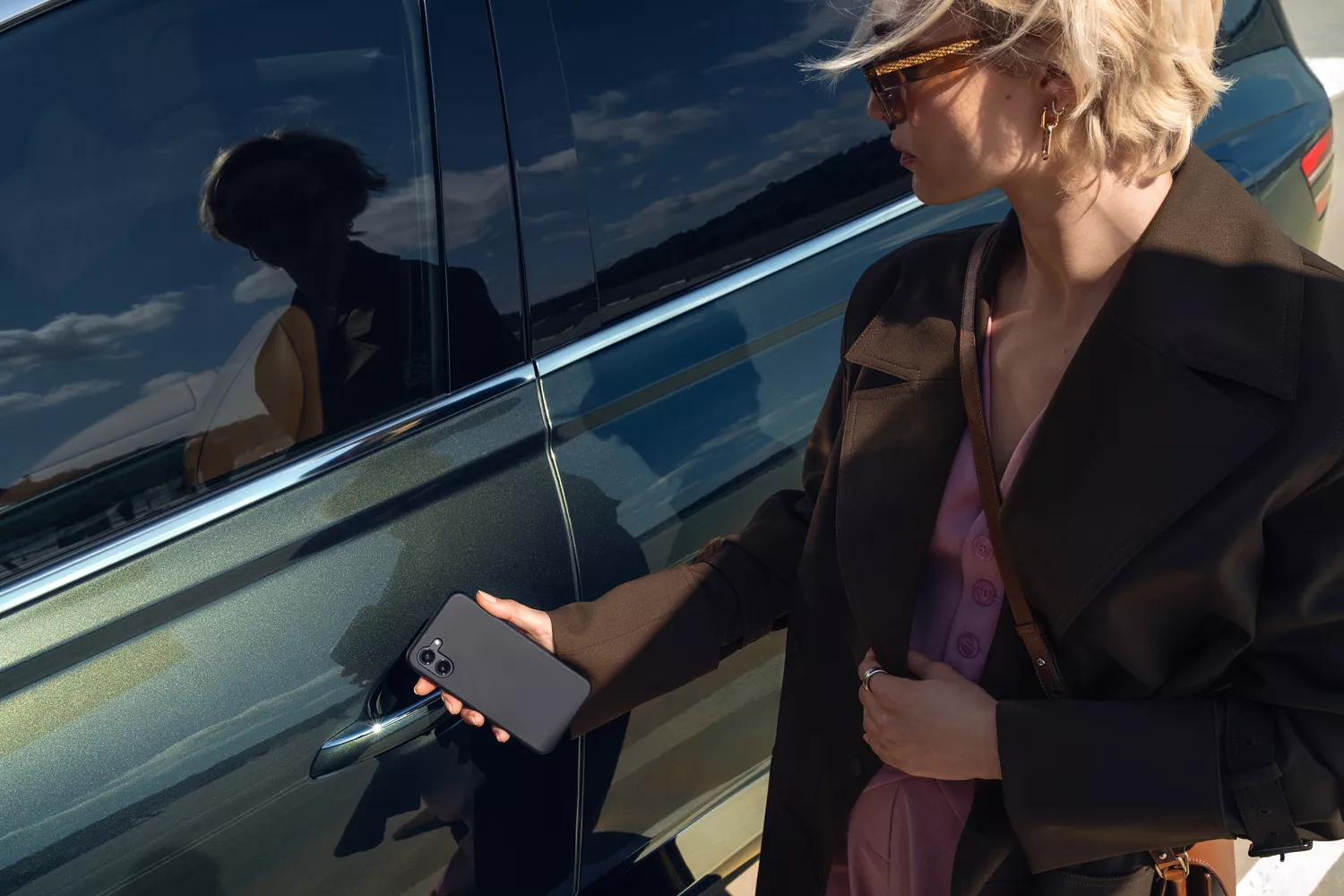 Exterior shot of person holding smartphone Digital Key up to Genesis GV80 driver side door