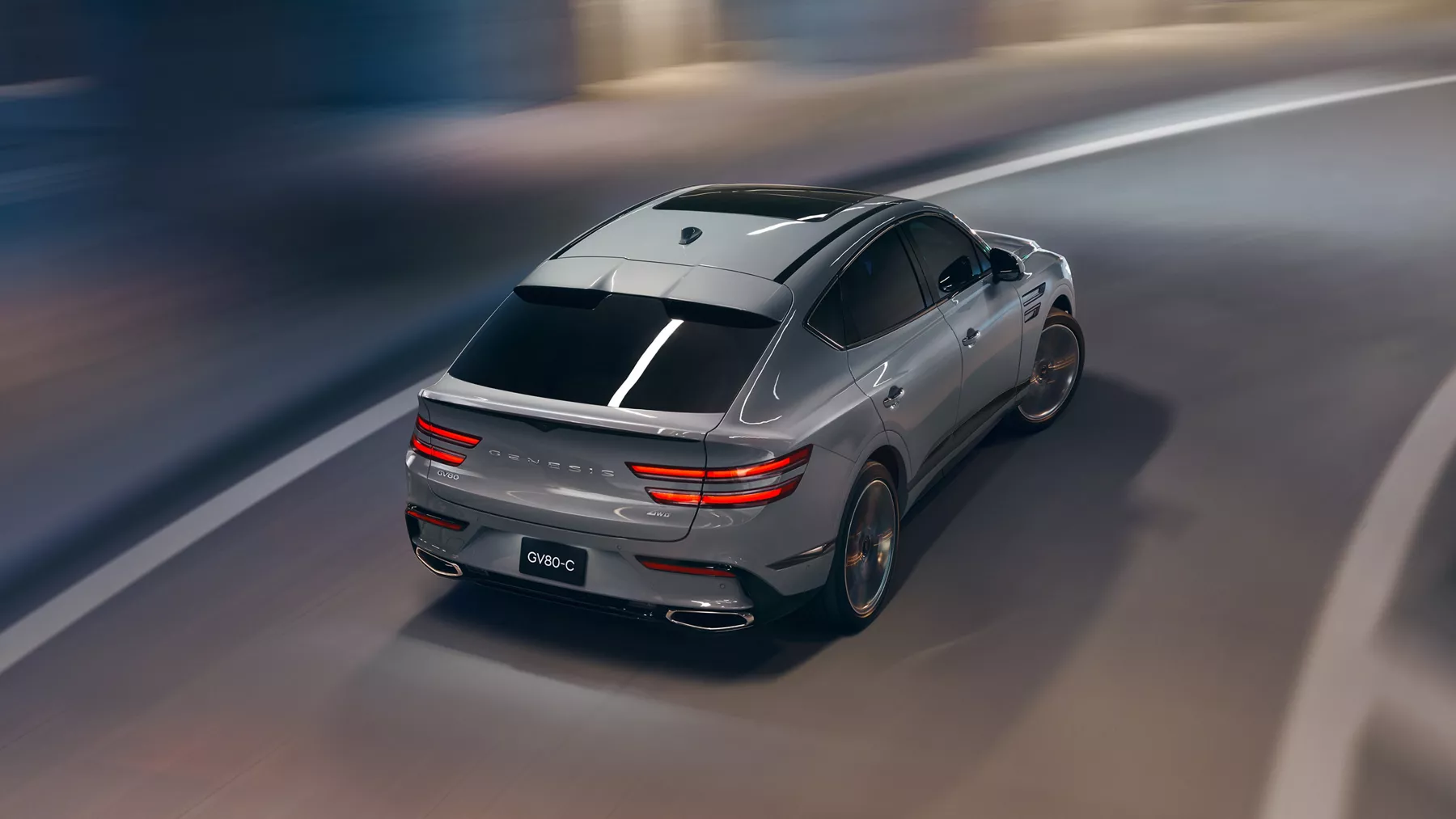 Rear overhead view of Genesis GV80 Coupe in Bering Blue driving through a parking structure