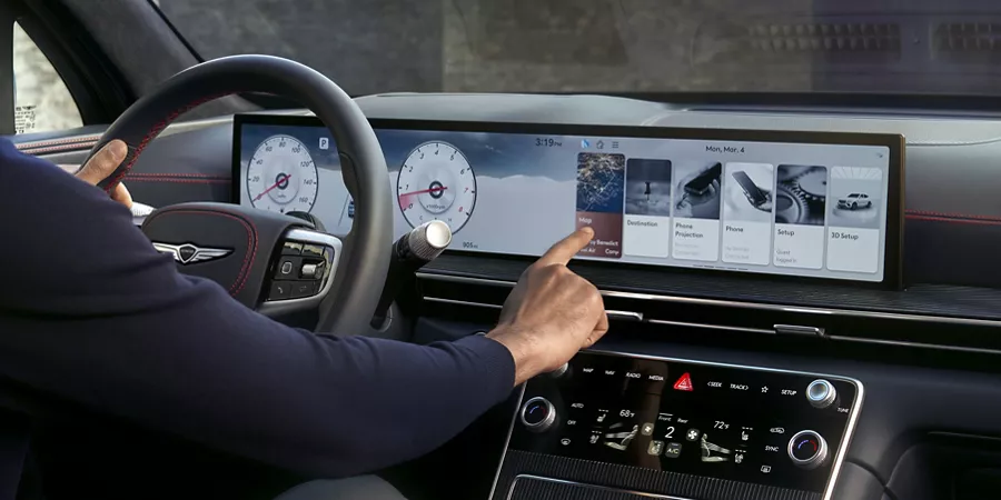 Interior view of driver touching the Navigation Integrated display inside the Genesis GV80 Coupe