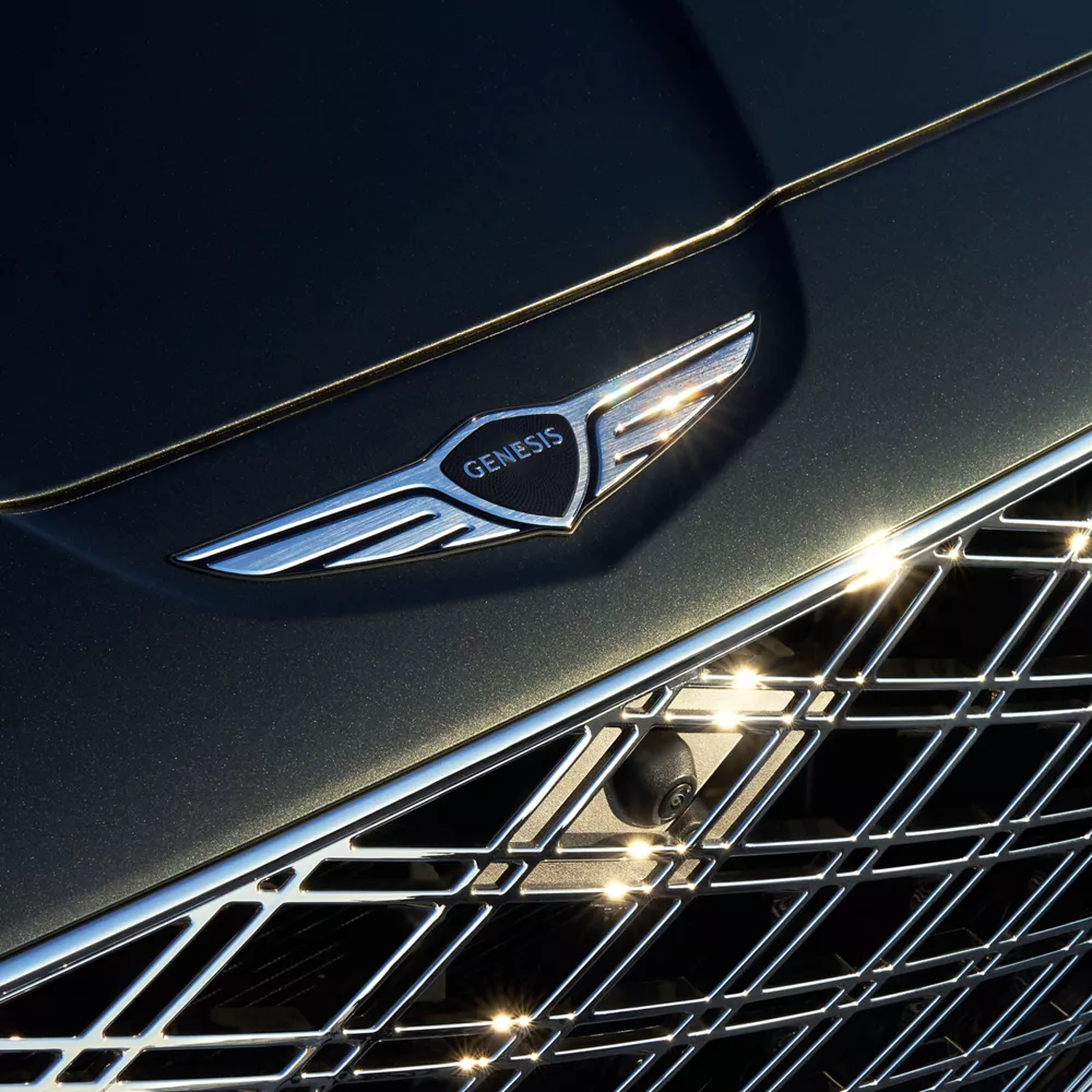 Close up of Genesis hood emblem on Genesis GV80 in Storr Green