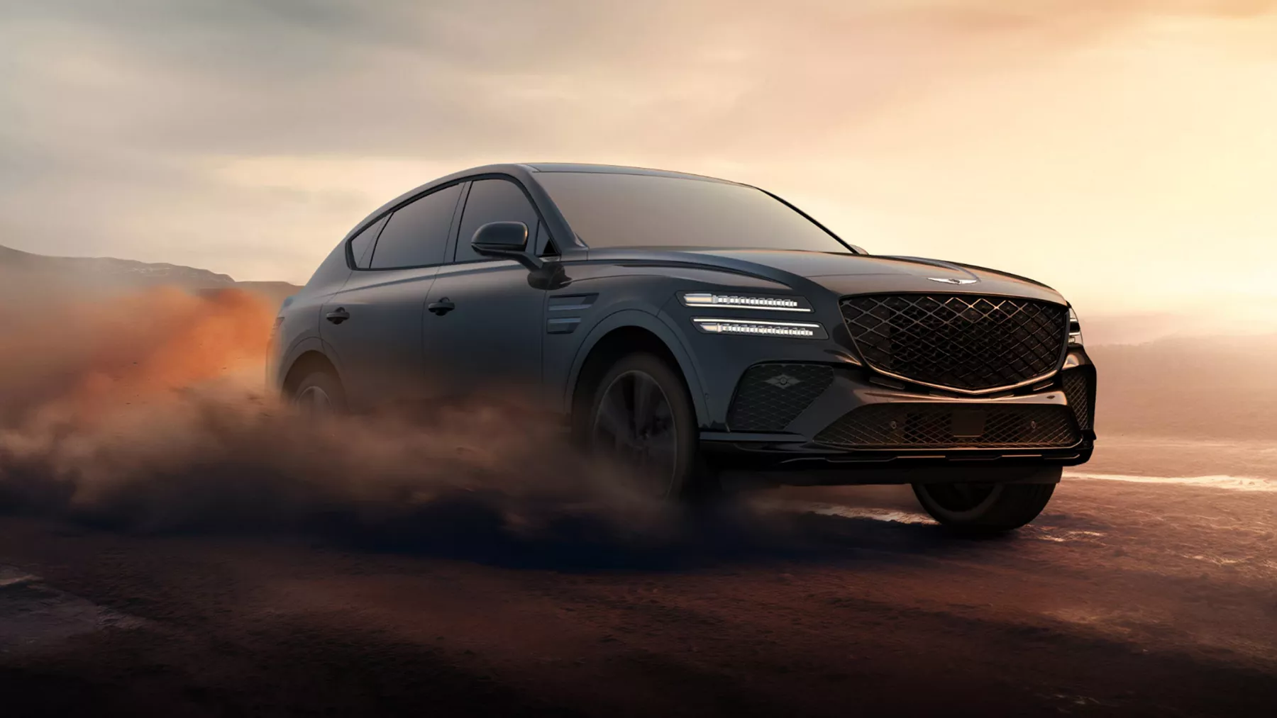 3/4 front passenger side view of Genesis GV80 Coupe driving on dusty road at sunset